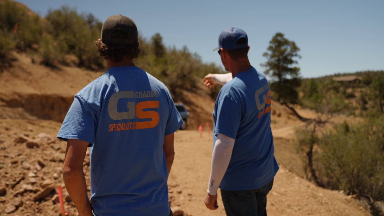 Two Grading Specialists crew members walking a graded site in the Prescott area