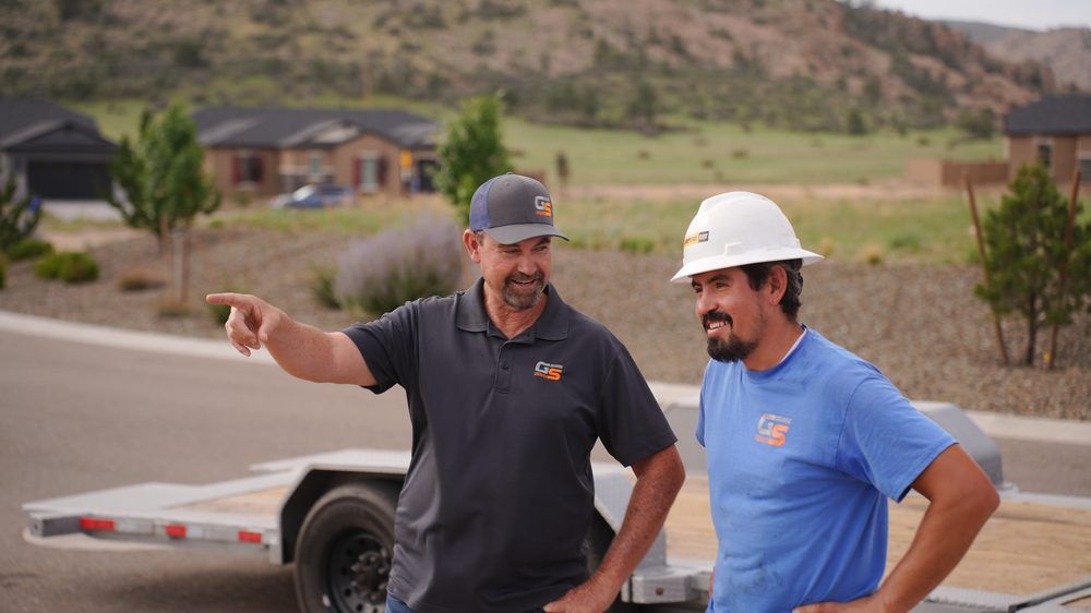 Grading Specialists owner pointing out site details to a crew member on a Prescott-area job site